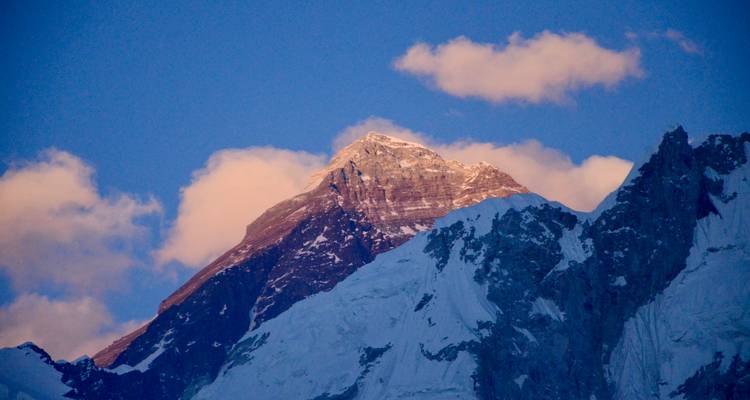 Der Mount Everest erstrahlt bei Sonnenuntergang in Rosa, fotografiert von einem erhöhten Aussichtspunkt.