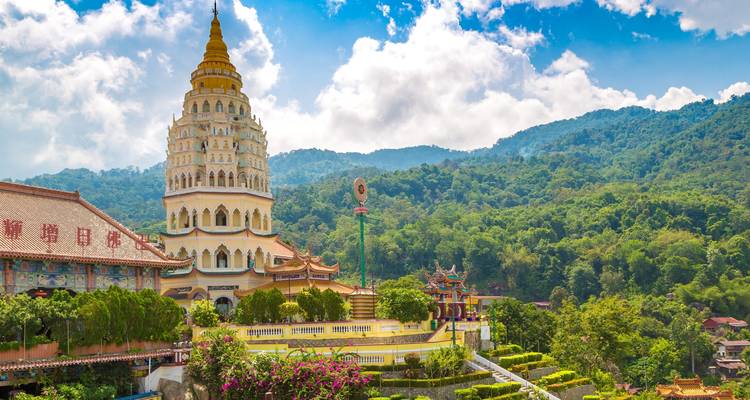 Multi-tiered Kek Lok Si Temple rises against lush green hills and a bright blue sky in Penang.