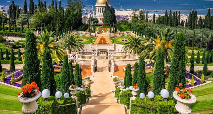 Immaculate terraced Bahai Gardens descending toward Haifa’s harbor with bright flowers and palms.