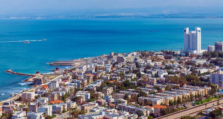Closer aerial of Haifa’s waterfront district, residential blocks and clear blue sea.