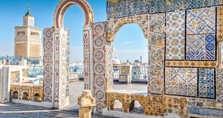 Los arcos con intrincados azulejos y los minaretes se elevan sobre los tejados de una medina histórica del norte de África.