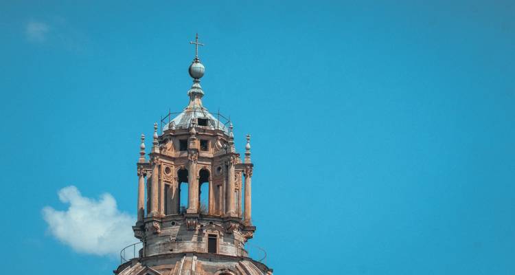 Gros plan d'un dôme d'église orné avec un ciel bleu en arrière-plan.