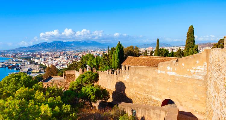 Panoramic view from Gibralfaro Castle walls across Malaga’s port, city and distant mountain range.