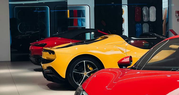 Rij met levendige rode en gele Ferrari supercars op een rij in een glanzende showroom.