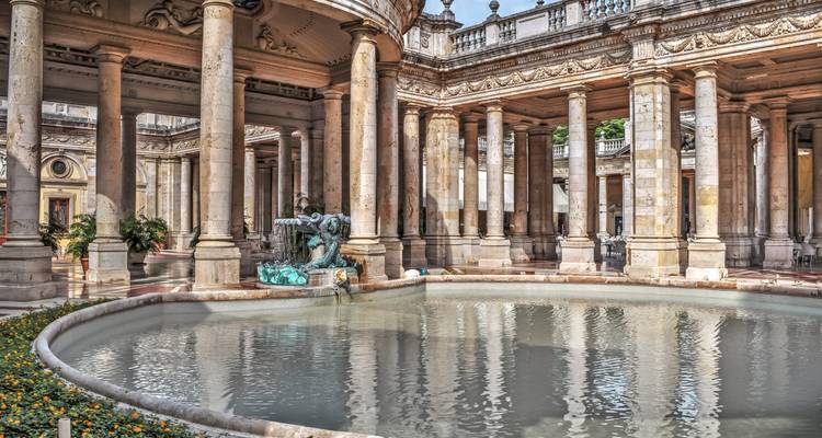 Pavillon à colonnes et bassin de fontaine de Montecatini Terme baignés de lumière solaire.