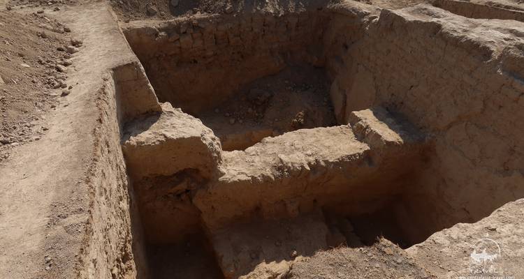 Exposed archaeological excavation trench showing ancient brick walls.