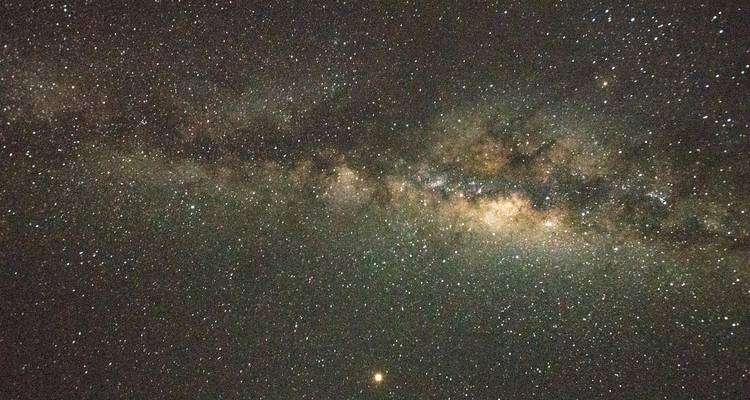 Milky Way core stretching across a clear night sky dotted with countless stars.