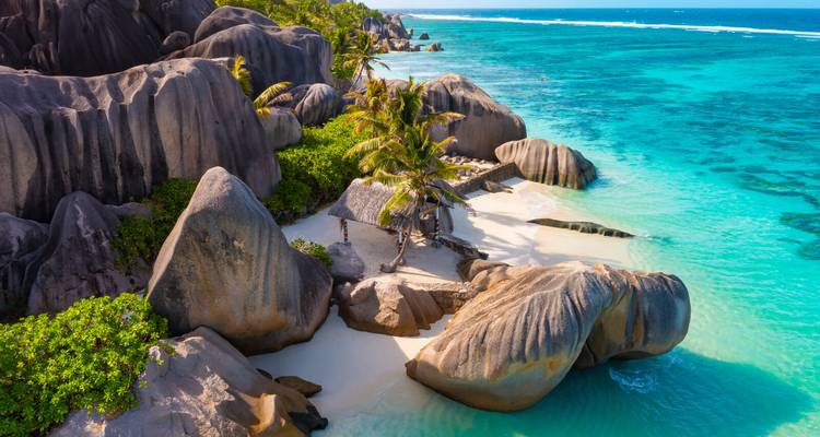 Aerial view of pristine white-sand cove, granite boulders and turquoise Indian Ocean in the Seychelles