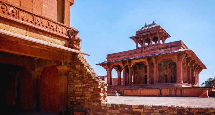 Red-sandstone pavilion and courtyard of Fatehpur Sikri’s royal complex under a bright sky.