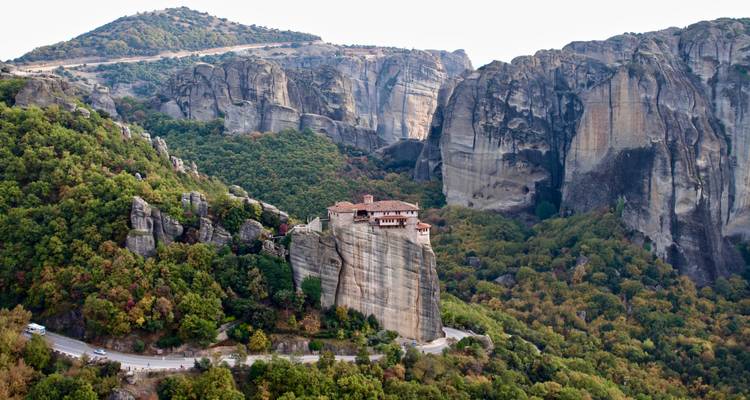 Monasterio encaramado en lo alto de un pilar de roca gigante rodeado de los acantilados de arenisca espectaculares de Meteora.