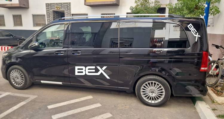 Black Mercedes van with 'BEX' branding parked in an urban street.