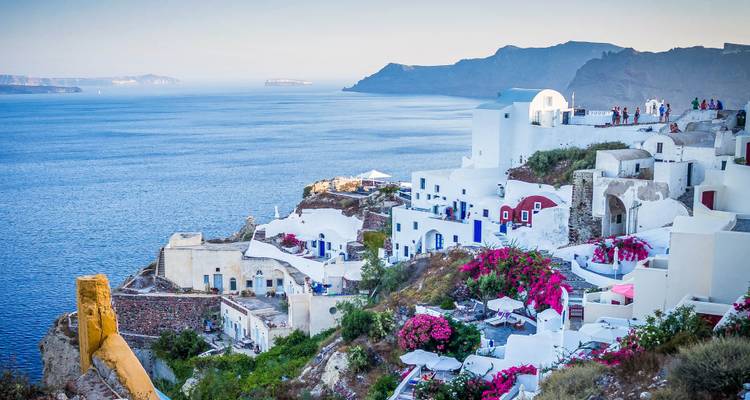Village emblématique perché sur les falaises d'Oia à Santorin avec ses maisons blanches, ses dômes bleus et ses bougainvillées dominant la mer Égée