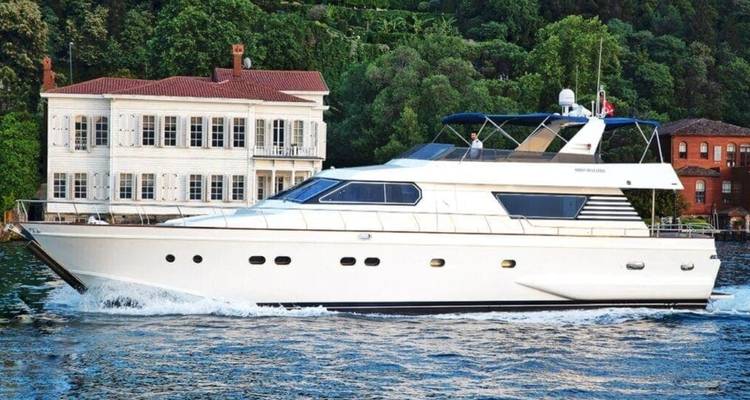 Luxury white motor-yacht cruising past historic Ottoman waterfront mansions on the Bosphorus.