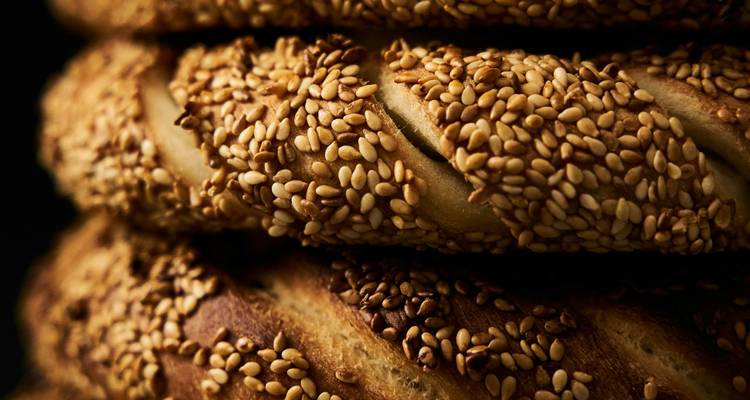 Stacked sesame-crusted simit breads in warm lighting.