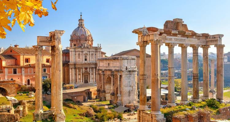 Ruines ensoleillées du Forum romain avec des colonnes classiques et des dômes encadrés par les feuilles d'automne