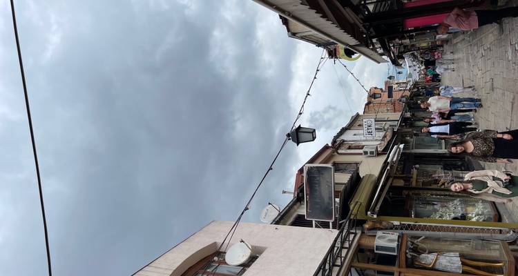 Calle estrecha del bazar con tiendas tradicionales y cielos nublados arriba.