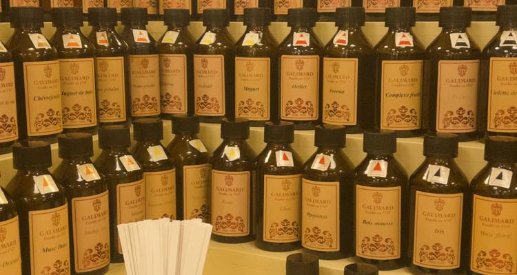 Display of assorted fragrance bottles labeled Galimard arranged on tiered shelves