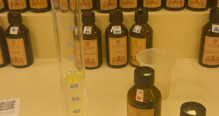Perfume workshop table with graduated cylinder, droppers and labeled scent bottles