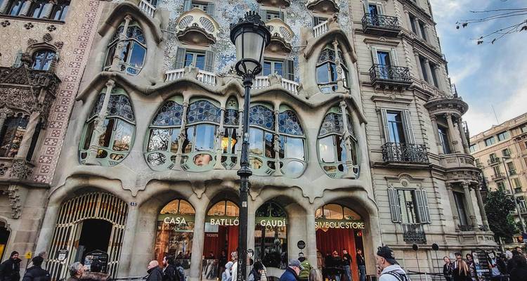 Vista a nivel de calle de la fachada de Casa Batlló con multitudes admirando el diseño de Gaudí.
