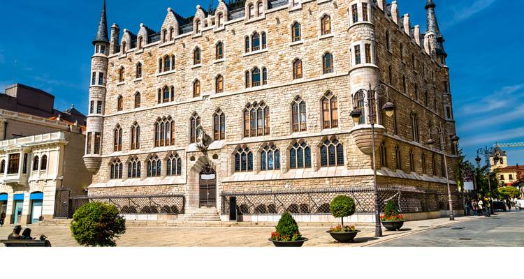 Wide shot of Casa Botines, Gaudí-designed neo-Gothic building in León, image bottom cropped white.