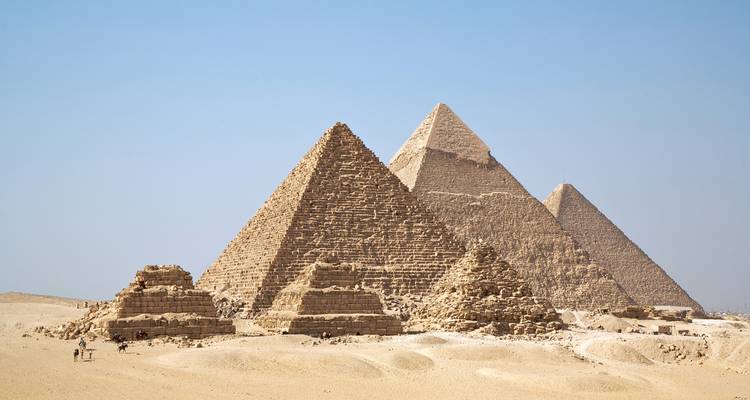 Una vista panorámica de las icónicas pirámides de Giza dominando el plano paisaje desértico.