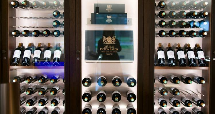 Display cabinet filled with bottles of Château Pichon Baron wine