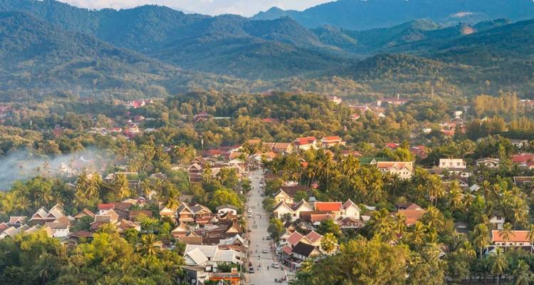 Vue panoramique aérienne d'une ville verdoyante nichée entre les montagnes ondulantes au Laos.