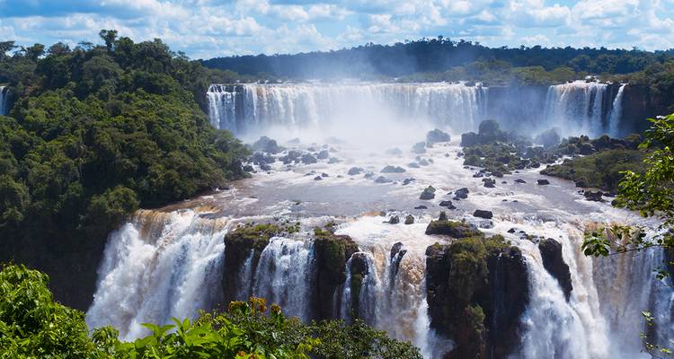 Kraftvolle, gestufte Wasserfälle von Iguazu, umgeben von tropischem Regenwald und Nebel.
