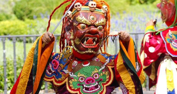 Danseur masqué coloré en tenue traditionnelle du festival bhoutanais durant sa représentation.