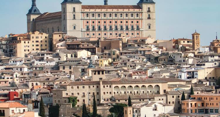 Vista panorámica de los densos tejadillos medievales de Toledo coronados por la imponente fortaleza del Alcázar.