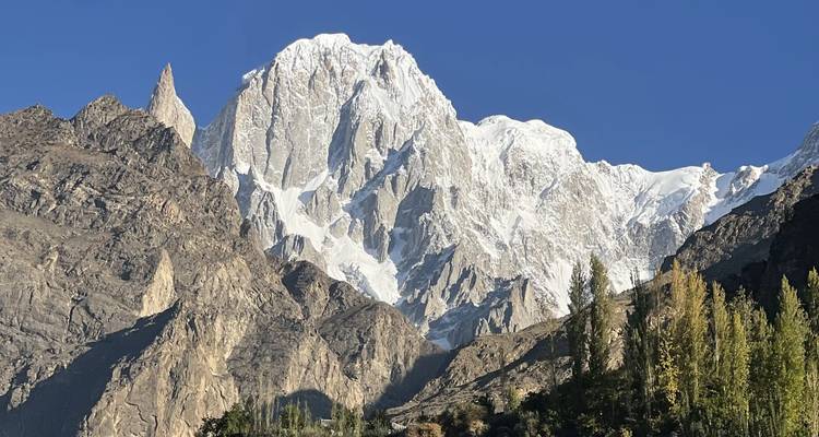 Schneebedeckter Gipfel, der sich scharf vor einem klaren blauen Himmel in der Karakorum-Kette erhebt.