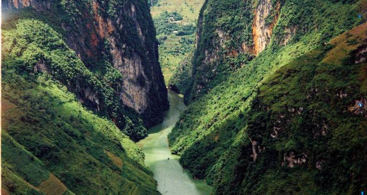 Rivière d'un vert émeraude sinuant entre les falaises vertes imposantes du canyon Tu San à Ha Giang.