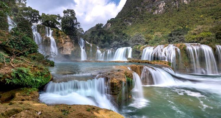 Les multiples cascades de la chute d'eau Ban Gioc-Detian se précipitant dans des bassins turquoise au milieu de la jungle.