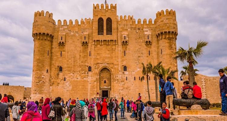 Visitantes deambulando por las imponentes murallas de la Ciudadela medieval de Qaitbay.