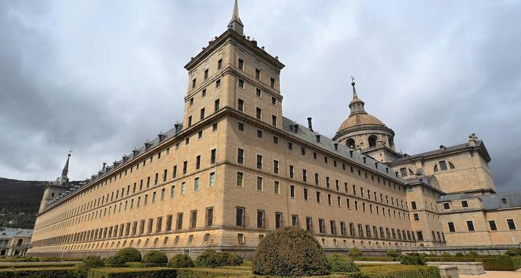 Complejo imponente del monasterio-palacio de El Escorial bajo un cielo gris dramático