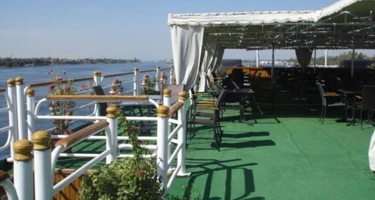 Onbedekt zonnedek op een rivierschip met uitzicht op rustig water en de verre oever.