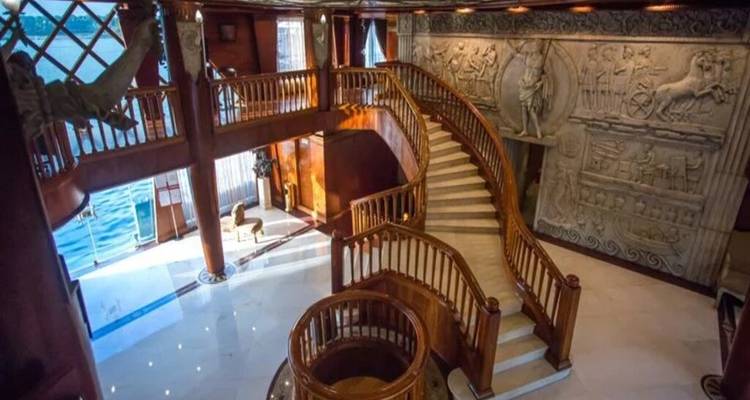 Atrio ornado con relieves de piedra tallada y una gran escalera curva en un crucero.