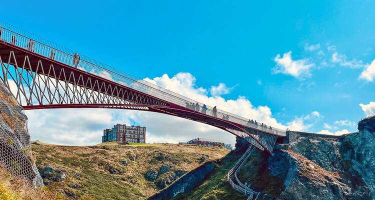 Moderne Fußgängerbrücke überquert eine dramatische kornische Schlucht in der Nähe der Ruinen von Tintagel Castle