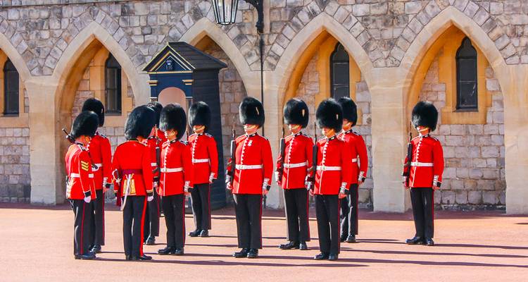 Wachen in leuchtend roten Uniformen stehen in Formation im Innenhof von Schloss Windsor