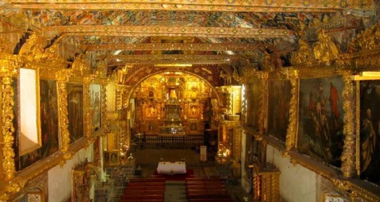 Lavishly gilded baroque interior of Andahuaylillas Church with ornate altar and ceiling artwork.