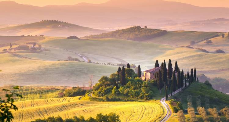 Golden sunrise bathes rolling Tuscan hills, cypress trees and a farmhouse in Val d’Orcia.
