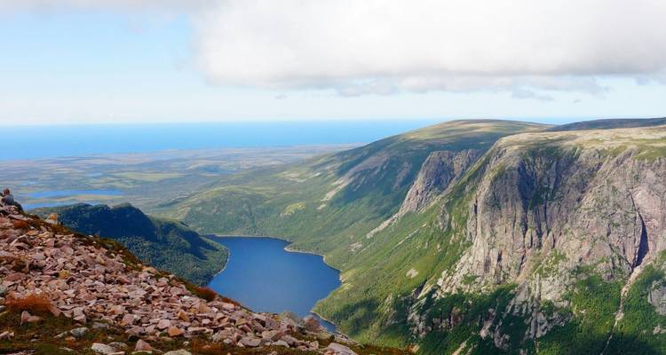 Sweeping vista over a dramatic fjord-like valley and lake beneath sheer cliffs in Gros Morne National Park.