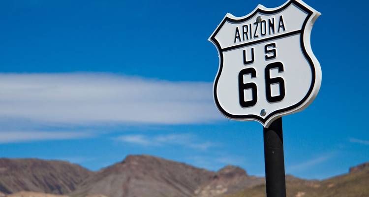 Klassisches US Route 66 Verkehrsschild vor blauem Wüstenhimmel.