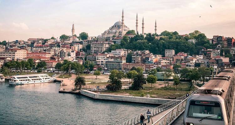 View across the Golden Horn with a modern metro bridge, ferries, and Istanbul’s historic skyline crowned by the Süleymaniye Mosque.