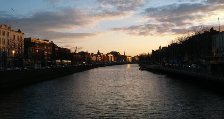 Serene sunset over the River Liffey with silhouettes of Dublin’s quays and bridges.