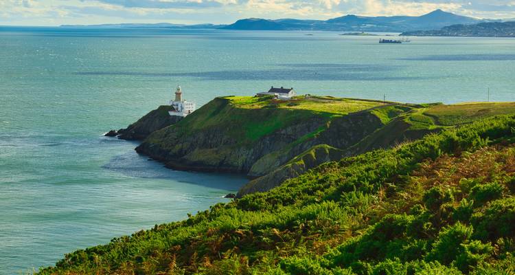 Cliff-top lighthouse on verdant headland overlooking the Irish Sea near Dublin’s Howth Peninsula.