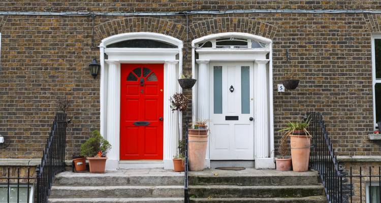 Classic Georgian brick façade with iconic red and white Dublin doors side by side.