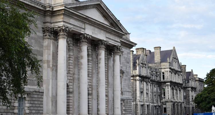 Neoclassical stone buildings and columns of Trinity College in Dublin.