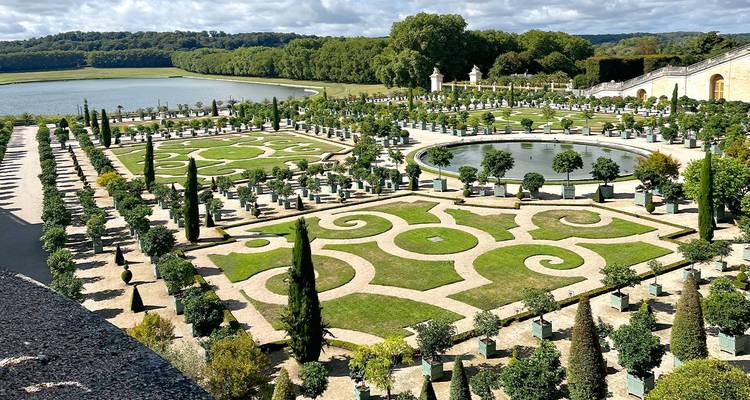 Les jardins à la française ornés de parterres aux motifs élaborés, les bassins et les rangées d'agrumes à Versailles.