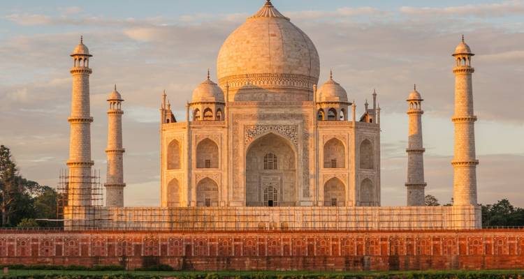 The Taj Mahal bathed in warm sunset light, reflecting its marble grandeur and symmetry.